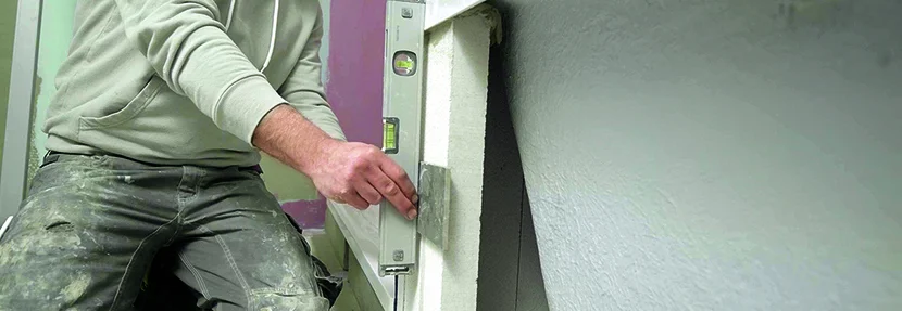 Person verwendet Wasserwaage beim Einbau